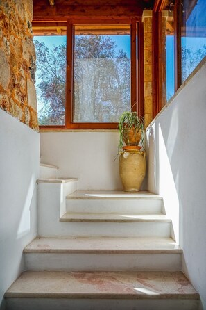 A staircase with a potted plant, leading to a window overlooking trees. - Torre del Drago - Three Bedroom Villa, Sleeps 6 (Marina di Felloniche)