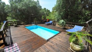 A wooden deck with a swimming pool, lounge chairs, and potted plants. - Torre del Drago - Three Bedroom Villa, Sleeps 6 (Marina di Felloniche)