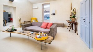 Un salon moderne comprenant un canapé, une table basse et une table d’appoint agrémentée d’objets décoratifs.