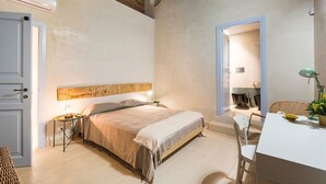 Une chambre à coucher avec un lit, une table de chevet, une lampe et une vue sur la salle de bain.