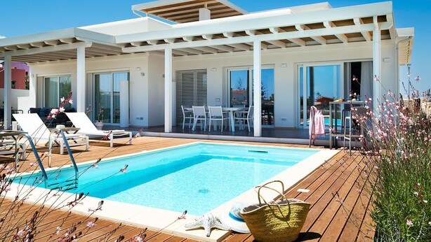 Un espace piscine extérieur moderne, agrémenté d’une pergola, de chaises longues et d’un coin repas.