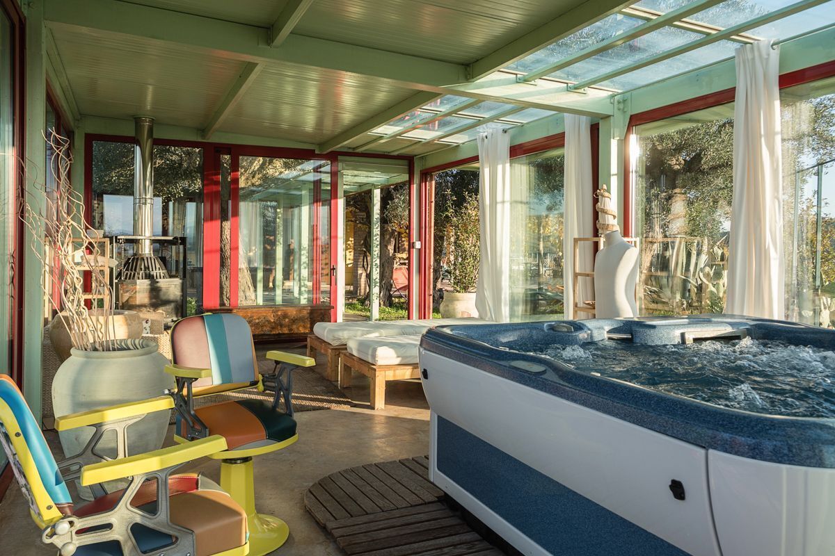 A spa area with a hot tub, seating, and a large window.