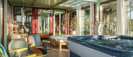 A spa area with a hot tub, seating, and a large window.