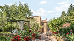 A stone building with a garden in front, a covered seating area, and a clear sky. - San Veriano - Five Bedroom Villa, Sleeps 10 (Ripoli)