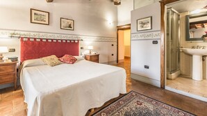 A bedroom with a large bed, a red headboard, a nightstand, a bedside table, a lamp, and a wall-mounted shelf. - San Veriano - Five Bedroom Villa, Sleeps 10 (Ripoli)