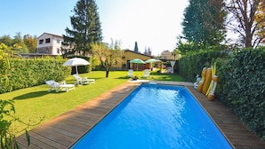 A rectangular swimming pool with a wooden deck, surrounded by a well-maintained lawn and hedges. - Casa Palanca - Two Bedroom Villa, Sleeps 4 (Capannori)