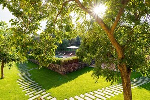 Een verzorgde tuin met een stenen muur, gazon en heldere lucht.