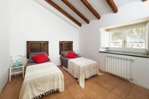 A bedroom with two beds, a window, and a radiator.