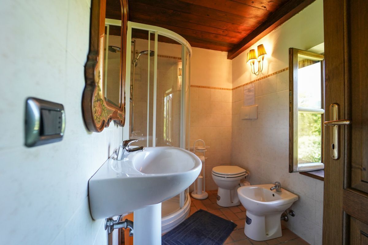Un bagno con lavandino bianco, un water, un bidet e un box doccia.