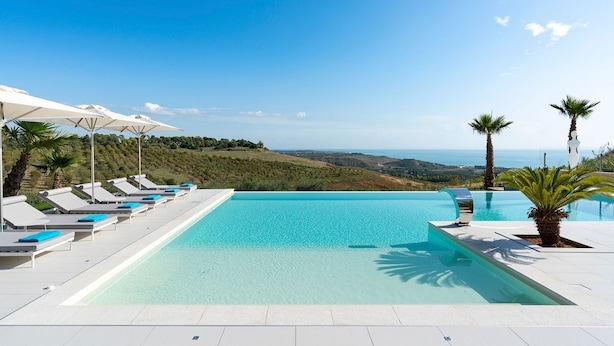 A pool area with lounge chairs and umbrellas, overlooking a scenic landscape. - Cella Mimavi - Three Bedroom Villa, Sleeps 6 (Ribera)