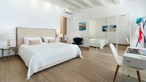 A modern hotel room with a large bed, a desk, a chair, and a mirror. - Cella Mimavi - Three Bedroom Villa, Sleeps 6 (Ribera)