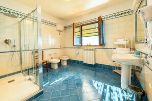 Ein Badezimmer mit Dusche, Toilette, Bidet und Waschbecken.