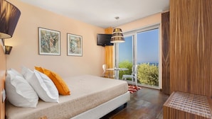 Un dormitorio con cama, televisor y balcón con vistas.