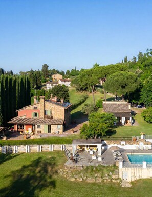 A residential area with stone buildings, a swimming pool, and a well-maintained lawn.