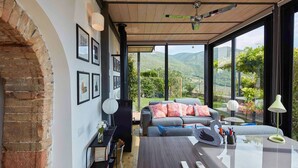 Una sala moderna con un ventanal grande, una chimenea y un comedor.