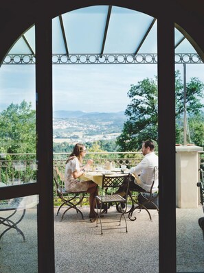 A couple dining at a table with a view of a landscape. - I Tebaldi - Eight Bedroom Villa, Sleeps 18 (Reggello)