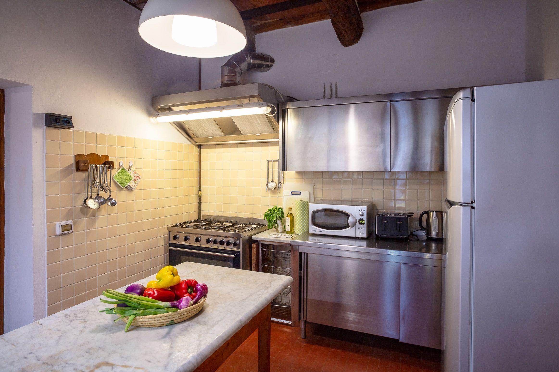 A kitchen with a gas stove, microwave, and stainless steel appliances.
