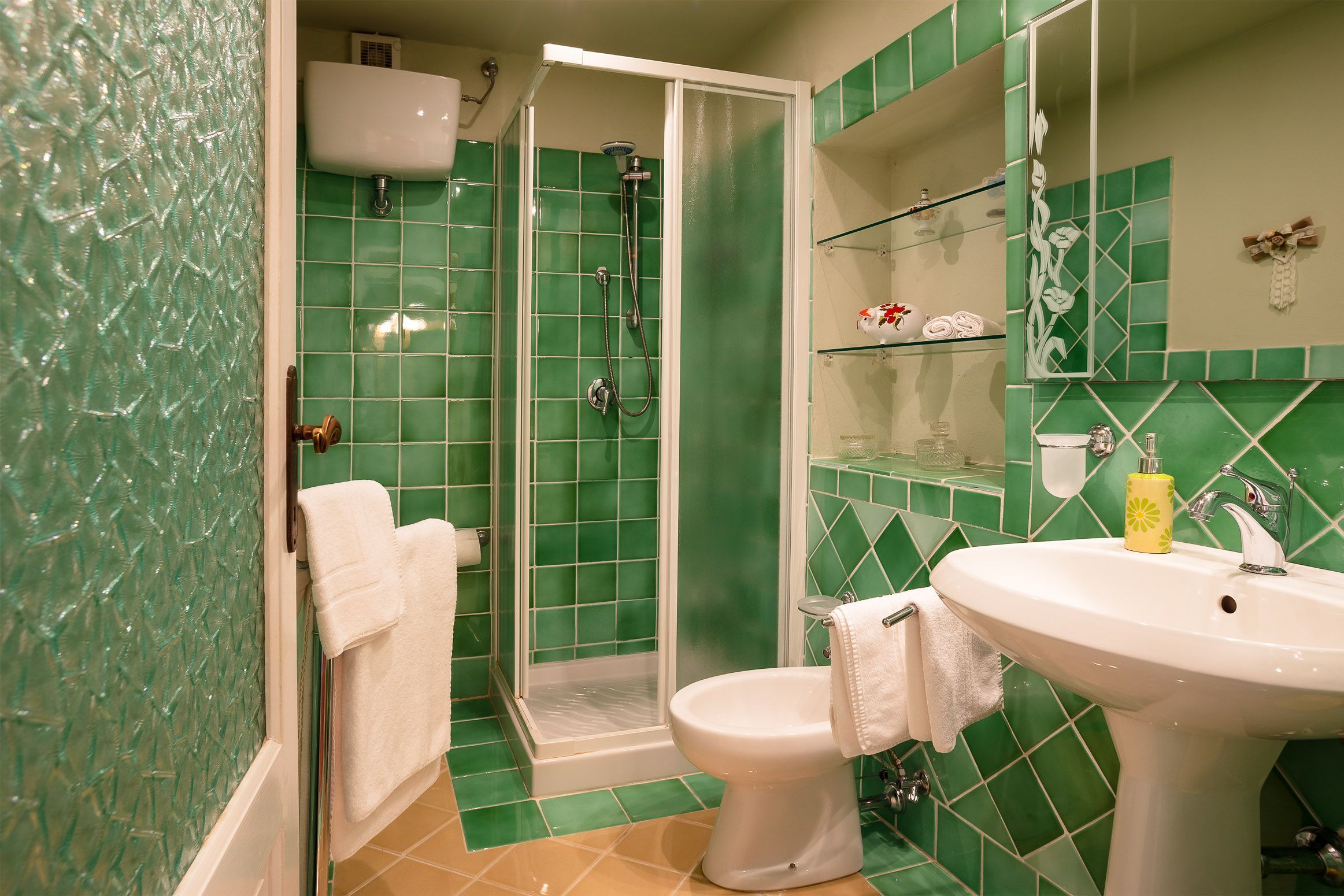 A bathroom with a shower, toilet, and sink.