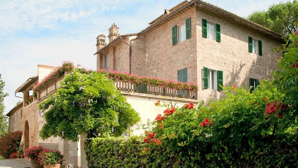 A stone building with green shutters, a balcony with flowers, and a garden with potted plants. - Tenuta Bartolucci - Ten Bedroom Villa, Sleeps 22 (Palaia)