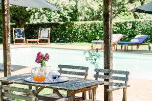 A wooden table with a pitcher of orange juice, a folded white towel, and pink flowers. - Villa Aquila - Six Bedroom Villa, Sleeps 12 (Capannori)