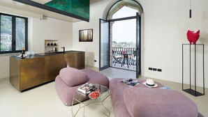 Un salon moderne comprenant un coin cuisine, une table à manger et une grande fenêtre donnant sur un paysage magnifique.