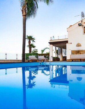 A clear blue pool with lounge chairs and a palm tree, reflecting the sky. - Villa Naxos - Eight Bedroom Villa, Sleeps 18 (Taormina)