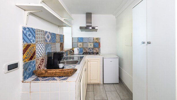 A compact kitchen with a gas stove, a coffee machine, and a small refrigerator. - Villa Naxos - Eight Bedroom Villa, Sleeps 18 (Taormina)