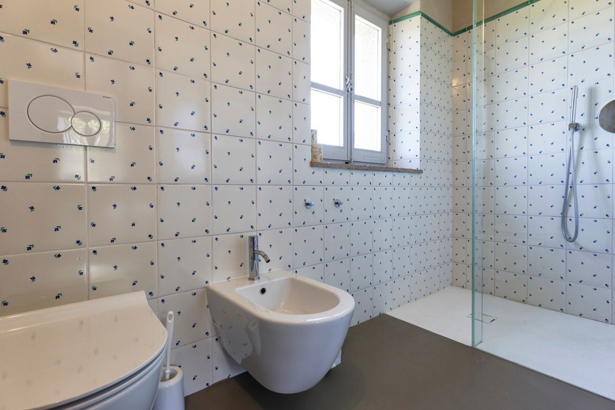 Ein modernes Badezimmer mit Bidet, Toilette und einer Duschkabine.
