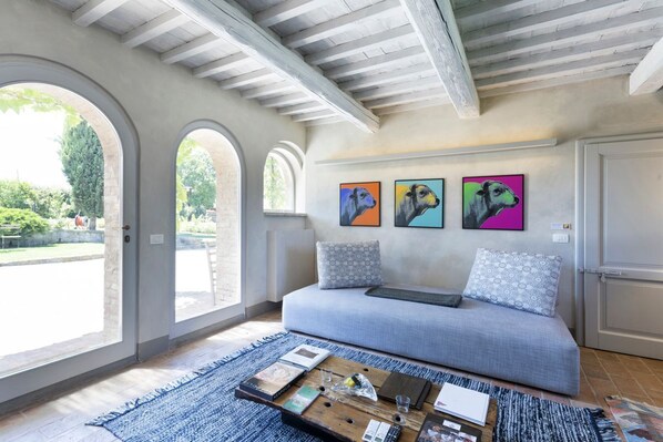A modern living room with a sofa, coffee table, and artwork on the wall.