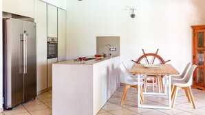 Eine moderne Küche mit Kochinsel, Edelstahlgeräten und Holzboden.