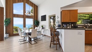 Una cucina moderna con mobili in legno, un'area pranzo con vista e un bancone.