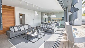 A modern living area with a sofa set, coffee table, and pendant lighting.