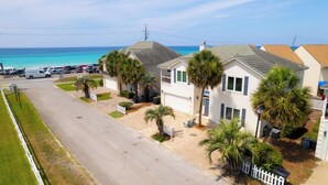 A coastal residential area with houses, a road, and a parking lot.