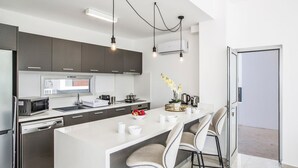 A modern kitchen with a central island, stainless steel appliances, and pendant lighting. - Villa Aglaia - Three Bedroom Villa, Sleeps 8 (Πρωταράς)