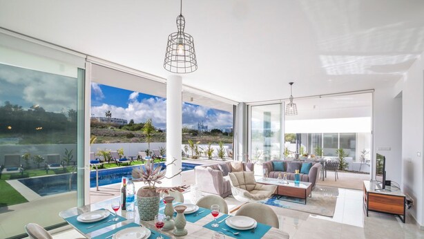 A modern dining area with a view of a pool and landscape. - Villa Aglaia - Three Bedroom Villa, Sleeps 8 (Πρωταράς)
