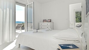 A bedroom with a bed, a nightstand, a dresser, and a view of the outdoors. - Villa Dinara - Three Bedroom Villa, Sleeps 6 (Mimice)