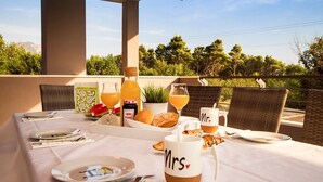 A table set for breakfast with a view of trees and a distant power line.