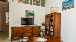 A living room with a wooden cabinet, a television, and a bookshelf. - Villa Lyubov - Three Bedroom Villa, Sleeps 9 (Tisno)