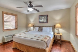 A bedroom with a bed, two bedside lamps, a ceiling fan, a radiator, and a framed picture on the wall. - Gone Fishing: Secluded Cabin in Woods Overlooking Beautiful Mountain Stream (Gatlinburg)