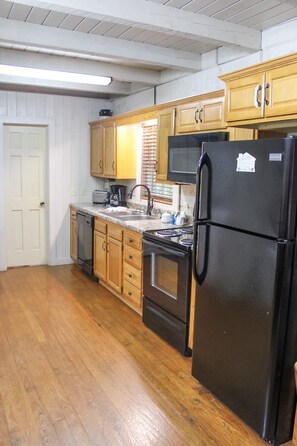 Kitchen equipped with oven, microwave, and refrigerator.
