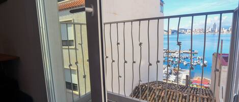 A balcony with a view of a marina and city skyline.