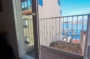 Uma varanda com vista para um porto de iates e o horizonte da cidade.