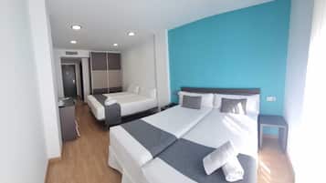 Una habitación de hotel moderna con dos camas, un escritorio y un armario.