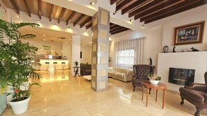 A spacious living area with a modern kitchen, a fireplace, and a large plant. - Hotel Clopy Rocamar (Benidorm)