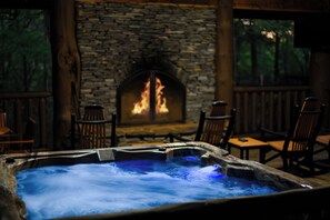 Un jacuzzi con una chimenea de piedra al fondo.