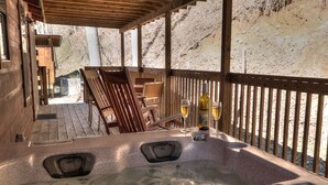 A hot tub area with wooden chairs and a wooden deck.