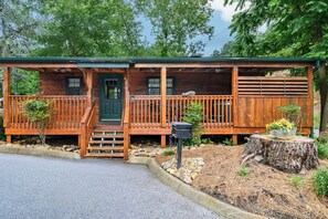 A wooden cabin with a porch, a front door, and a mailbox.