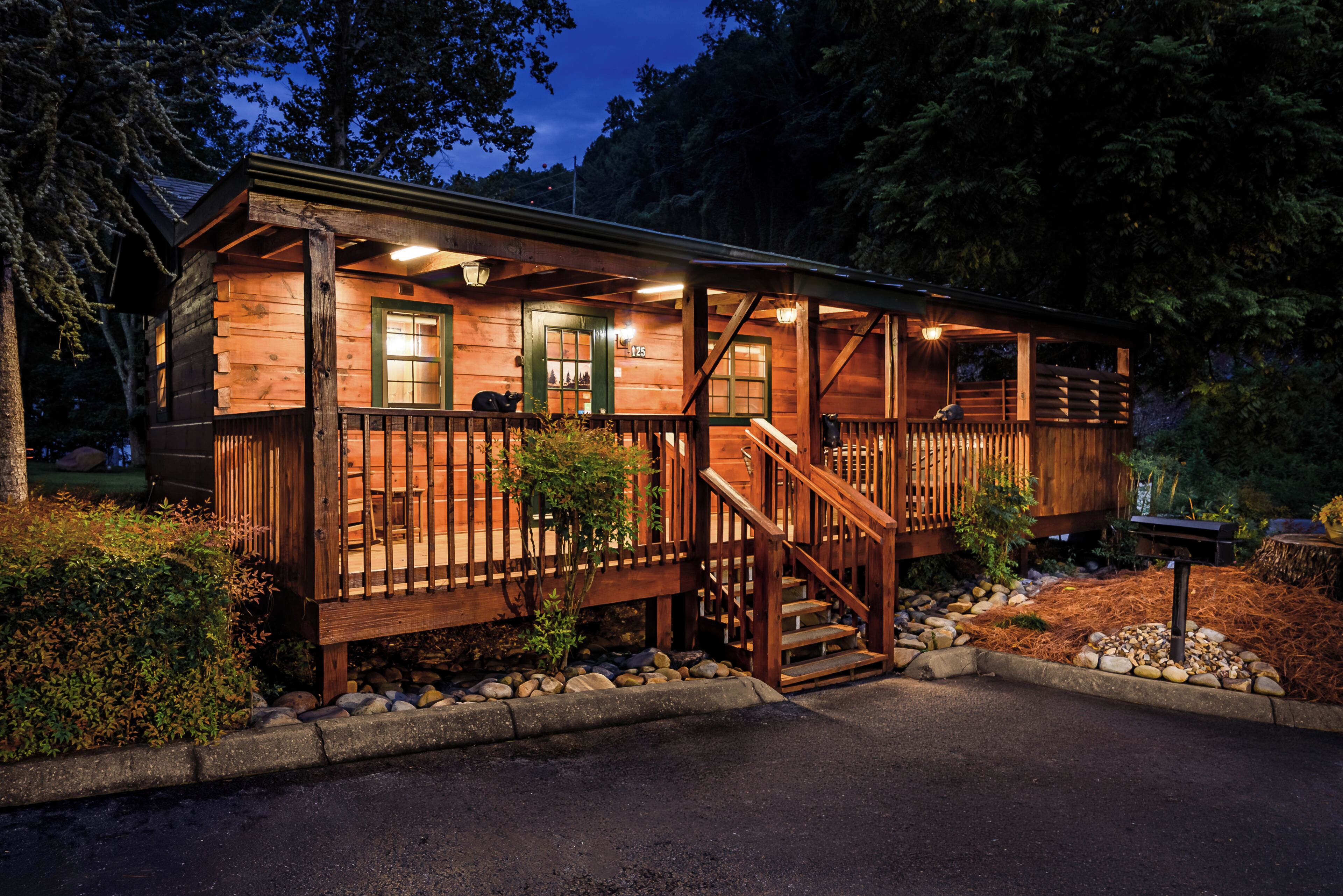 A wooden cabin with a porch, a staircase, and a small deck area.