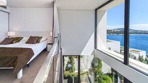 Un dormitorio moderno con balcón y vistas a la costa.