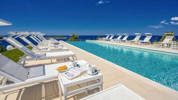 An infinity pool, sun loungers